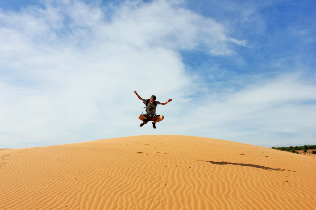Luke jumping sand dunes in Vietnam - Charlie on Travel