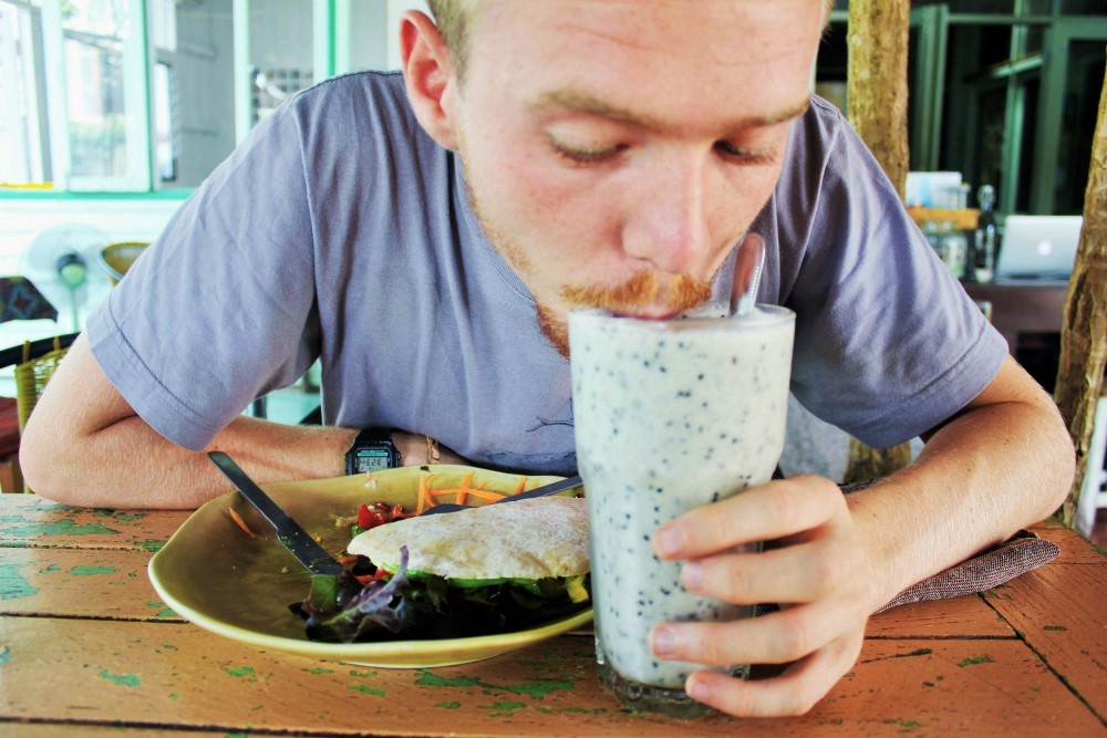 Luke drinking sesame smoothie at Imm Aim Vegetarian Chiang Mai - vegan travel - Charlie on Travel