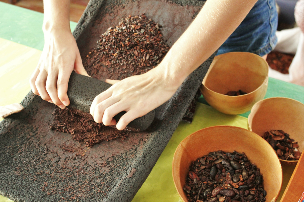Charlie making cacao paste at AJAW Chocolate San Ignacio Belize - Charlie on Travel
