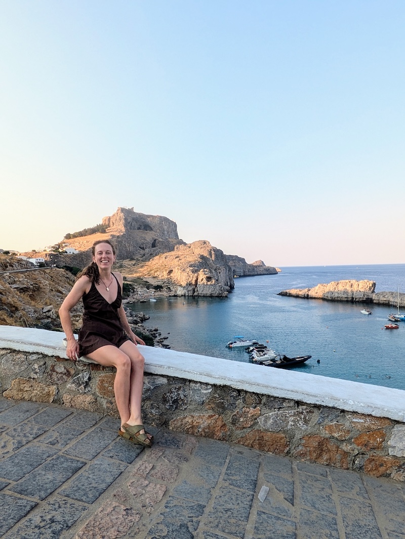 Charlie sitting on the wall above St Paul's Bay in Lindos, Rhodes