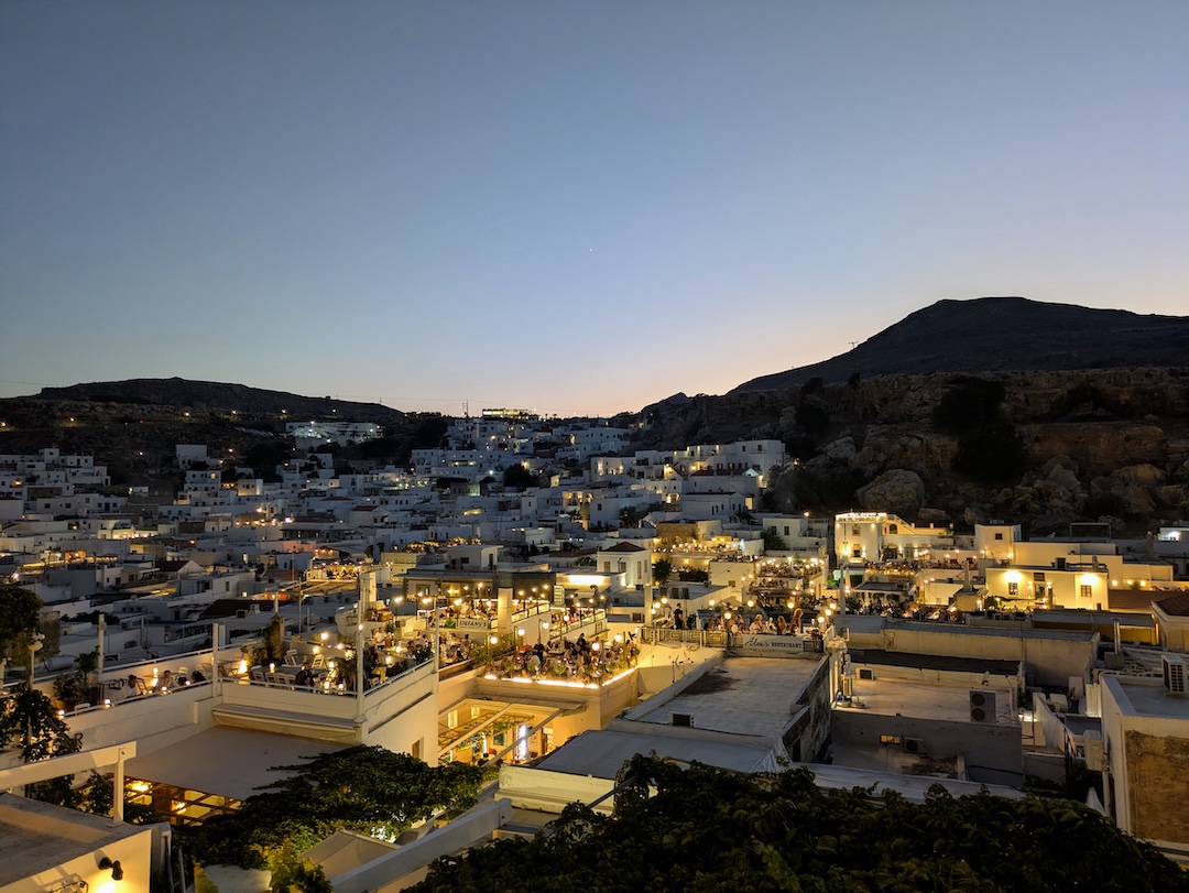 Rooftop terrace restaurant lit up in the evening in Lindos village, Rhodes
